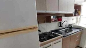 A kitchen with white cabinets, a stove, and a sink. - Valença Space - in the heart of the historic center (Centro Histórico Porto Alegre)