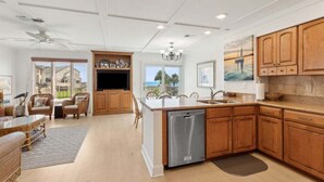 A spacious kitchen with wooden cabinets, a built-in dishwasher, and a large island. - 211 Sailmaker ~ Ocean Sunrise (Fernandina Beach)