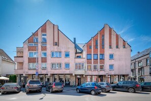 Ein mehrgeschossiges Gebäude mit einer symmetrischen Fassade, zahlreichen Fenstern und einem zentralen Eingang.