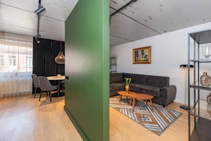Ein modernes Wohnzimmer mit einer Couch, einem Couchtisch und einem Gemälde an der Wand.