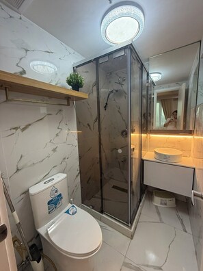 Een douche, een haardroger, een bidet, handdoeken