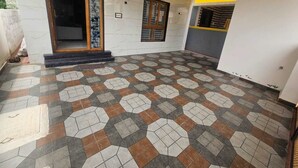 A spacious room with a patterned floor, a wooden door, and a small window.