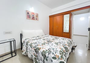 A bedroom with a bed, a wardrobe, a bedside table, and wall-mounted artwork. - The Pinnacle - Electronic city, Bengaluru (Bengaluru)