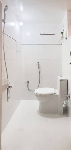 Une salle de bain moderne équipée de toilettes, d’une douche et d’un lavabo.