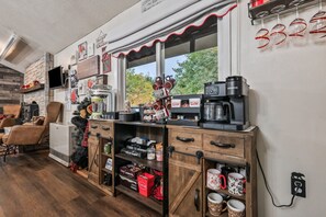 Un espace cuisine accueillant, doté d’un coin café, d’une cheminée et offrant une vue sur l’extérieur.
