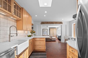 Una cocina moderna con armarios de madera, un refrigerador de acero inoxidable y una isla central con asientos.