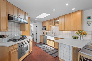 Una cocina moderna con armarios de madera, una isla central, un microondas y un fregadero.