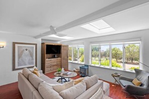 Una sala de estar amplia con sofá, televisor y chimenea.