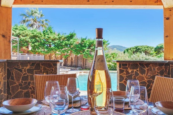 A table set for dining with a bottle of wine, glasses, and a bowl of sugar.