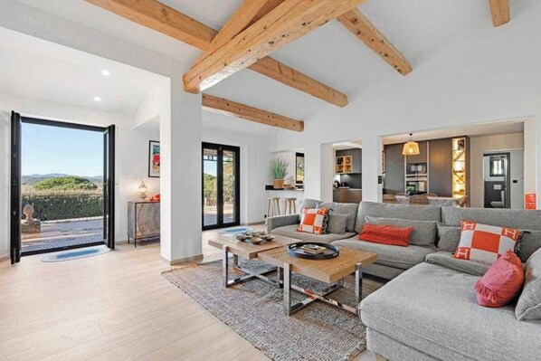 A spacious living area with a sofa, coffee table, and a view of the outdoors.