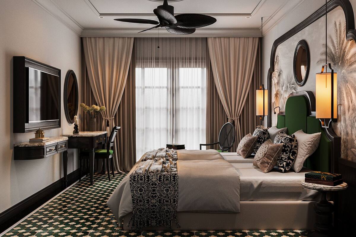 A hotel room with a large bed, a desk with a chair, a vanity with a mirror, and a ceiling fan.