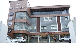A multi-story building with a modern design, featuring a restaurant named "Raja Avis" on the ground floor.