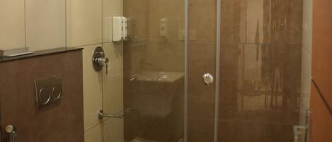 Ein modernes Badezimmer mit einer Glasdusche, einer Toilette und einem Waschbecken.