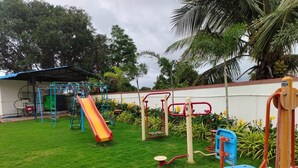 Un parque infantil con diversos juegos, incluyendo un tobogán, columpios y estaciones de ejercicio.