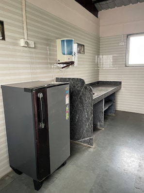 Geladeira, micro-ondas em uma área comum, cooktop