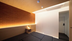 Una habitación moderna con pared de madera, una mesita de noche pequeña y un sofá.