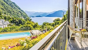 A balcony with a pool, a garden, and a view of a lake and mountains. - Borgo Castello by Interhome (Argegno)