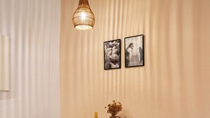 A dining area with a wooden table, two chairs, a hanging light fixture, and framed pictures on the wall. - Cosy cocoon in the heart of Bastia (Bastia)