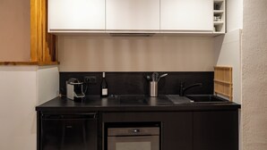 A modern kitchen with a black countertop, white cabinets, a built-in oven, and a dishwasher. - Cosy cocoon in the heart of Bastia (Bastia)