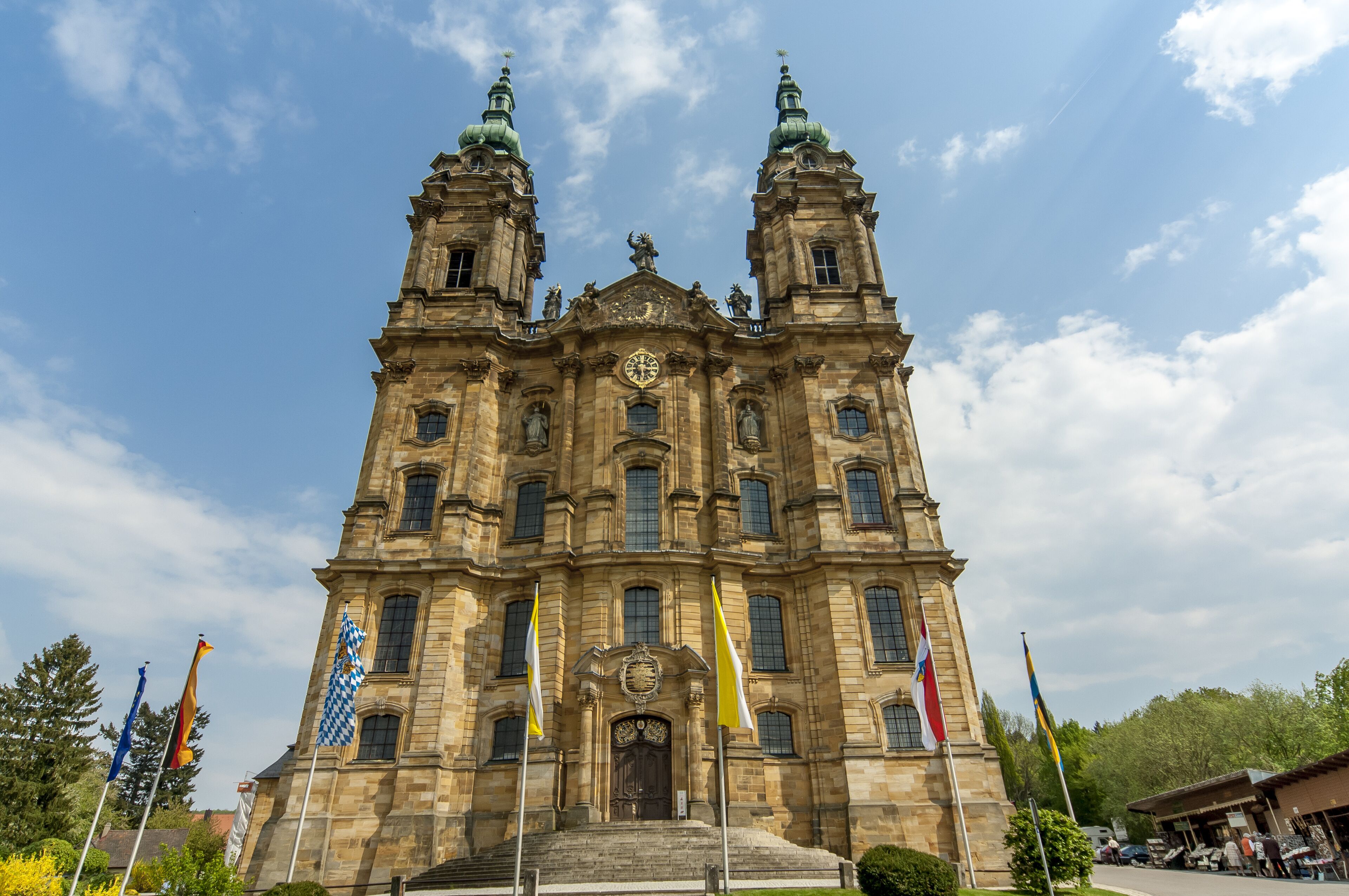 A large, historic building with two towers and a central clock.