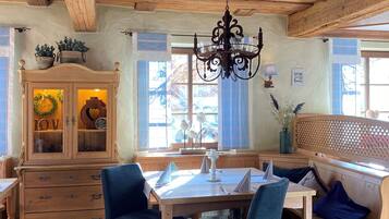 Un comedor acogedor con muebles de madera, una araña y vistas al exterior.