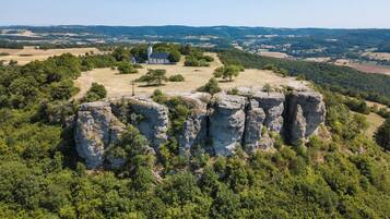A church surrounded by rocky terrain and dense forest.