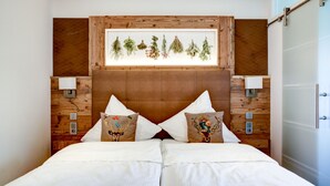 A double bed with white linens, two decorative pillows, a wooden headboard, and a framed botanical print above. - Landhotel Augustin (Staffelstein)