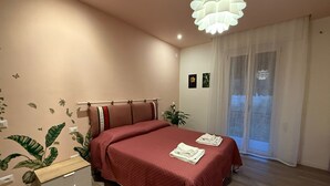 A bedroom with a bed, bedside tables, a plant, a window with curtains, and a ceiling light fixture. - To feeling at home "at ANGELA's" (Montelabbate)