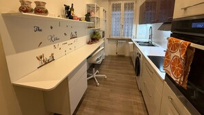 A modern kitchen with white cabinetry, a built-in oven, and a window with curtains. - To feeling at home "at ANGELA's" (Montelabbate)