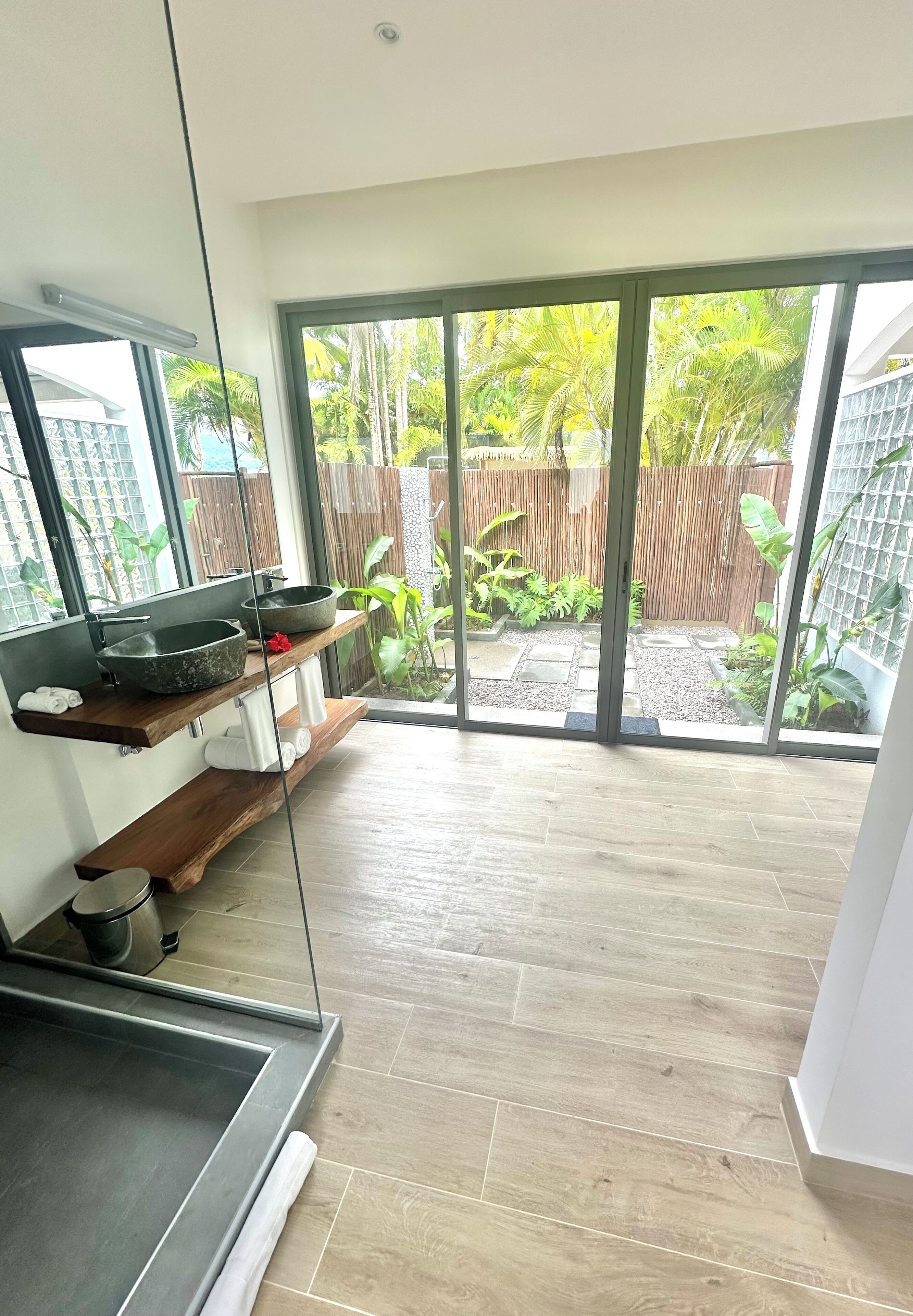 Un baño moderno con un espejo grande, dos lavamanos y una zona de ducha.
