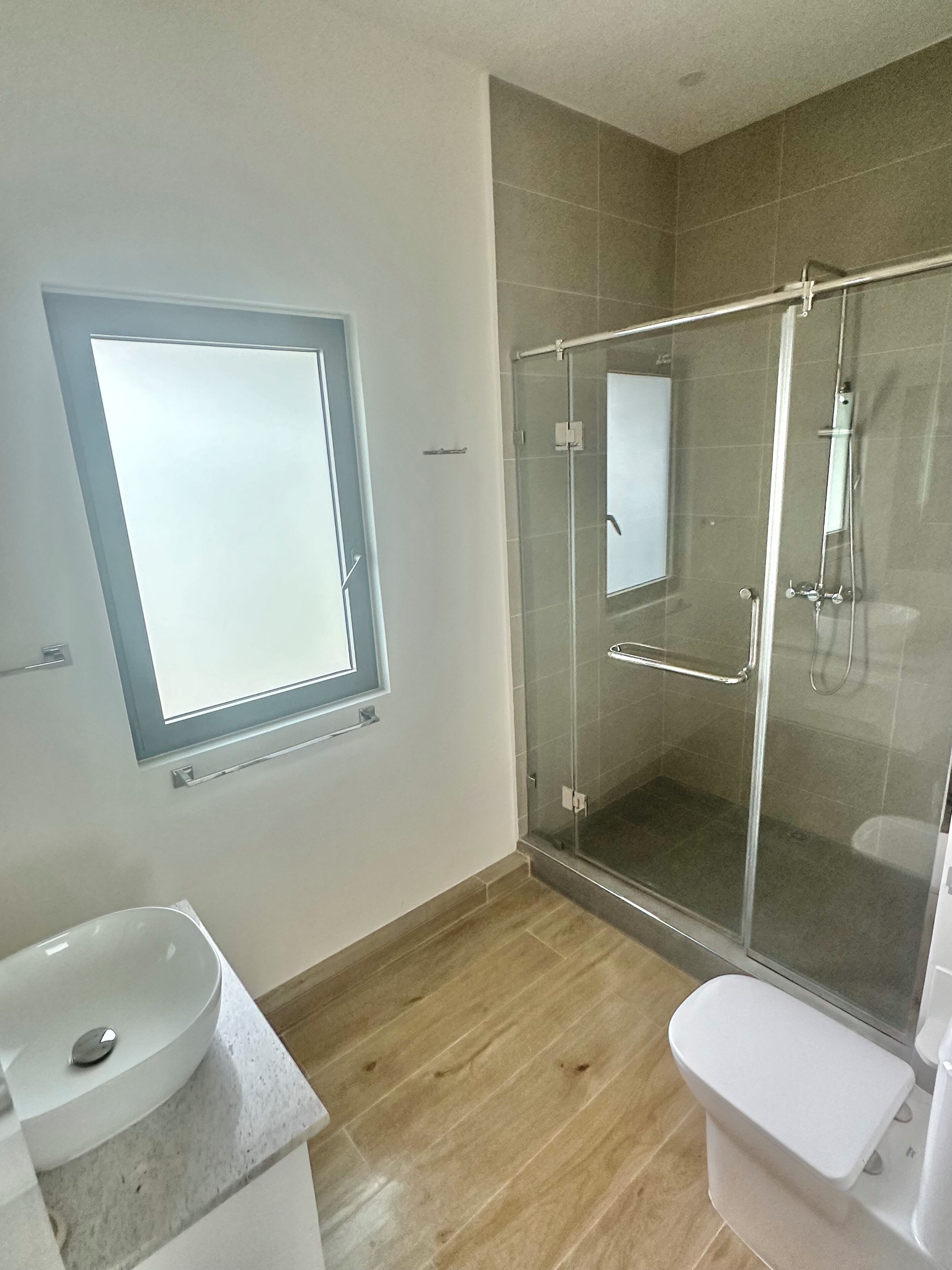 Ein modernes Badezimmer mit einer einteiligen Duschkabine, einer Toilette und einem Waschbecken.