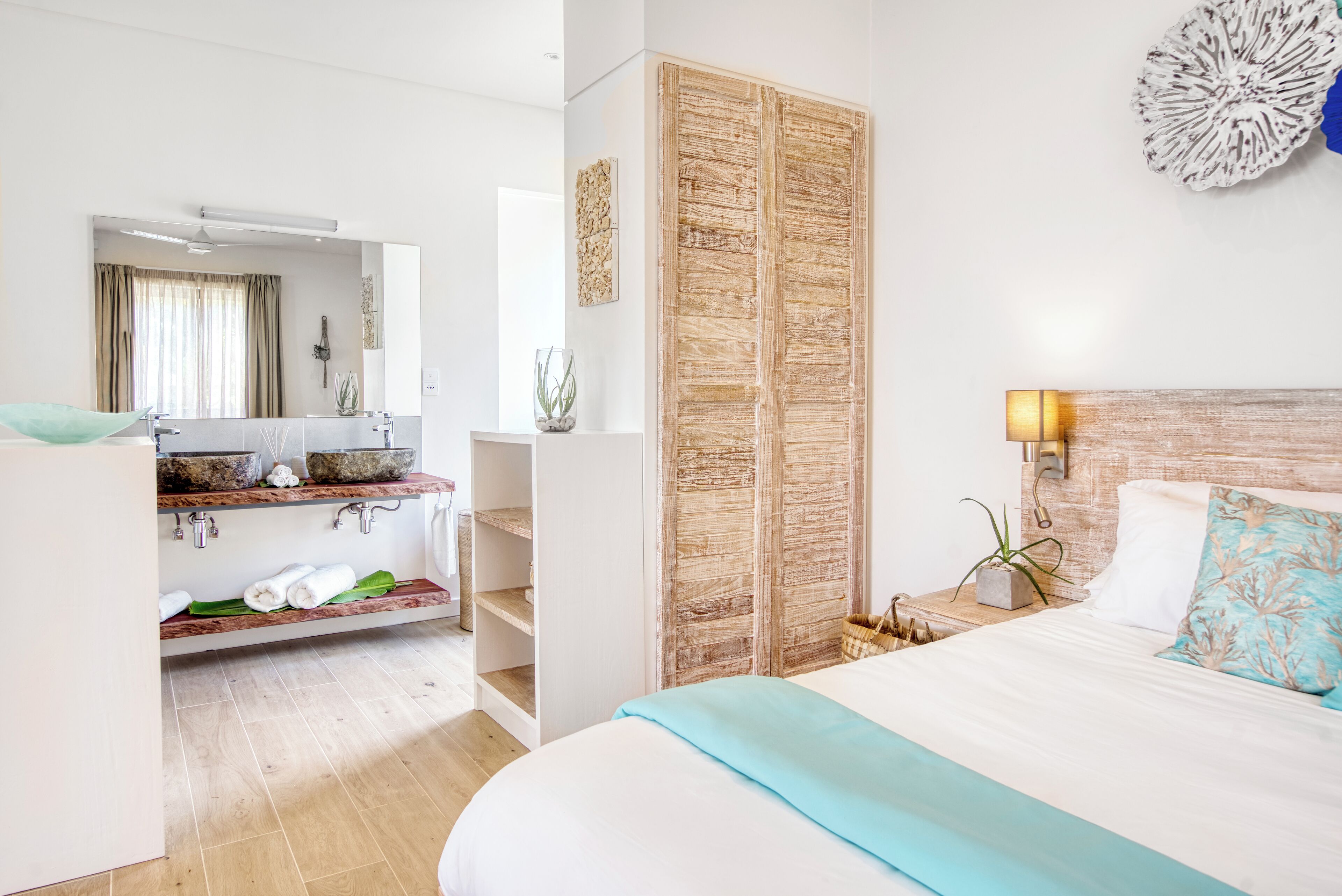 Una habitación de hotel moderna con una cama grande, un baño con tocador y un armario.