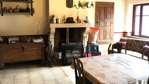 Un'area pranzo rustica con un tavolo in legno, sedie e un camino.