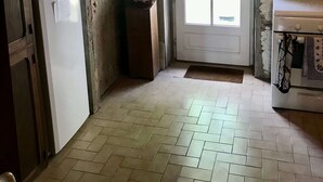 Cucina con frigorifero, forno e travi in legno al soffitto.