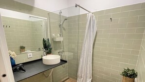 A bathroom with a shower, toilet, sink, and a mirror. - WAKAFLATS 2 CHUECA SB (Madrid)