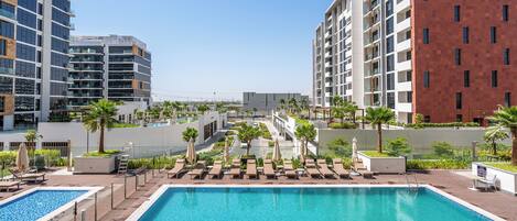 حمّام سباحة خارجي، مظلات على حمّام السباحة، مقاعد للتشمس