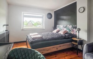Une chambre à coucher avec un lit, une fenêtre, une horloge et une chaise.