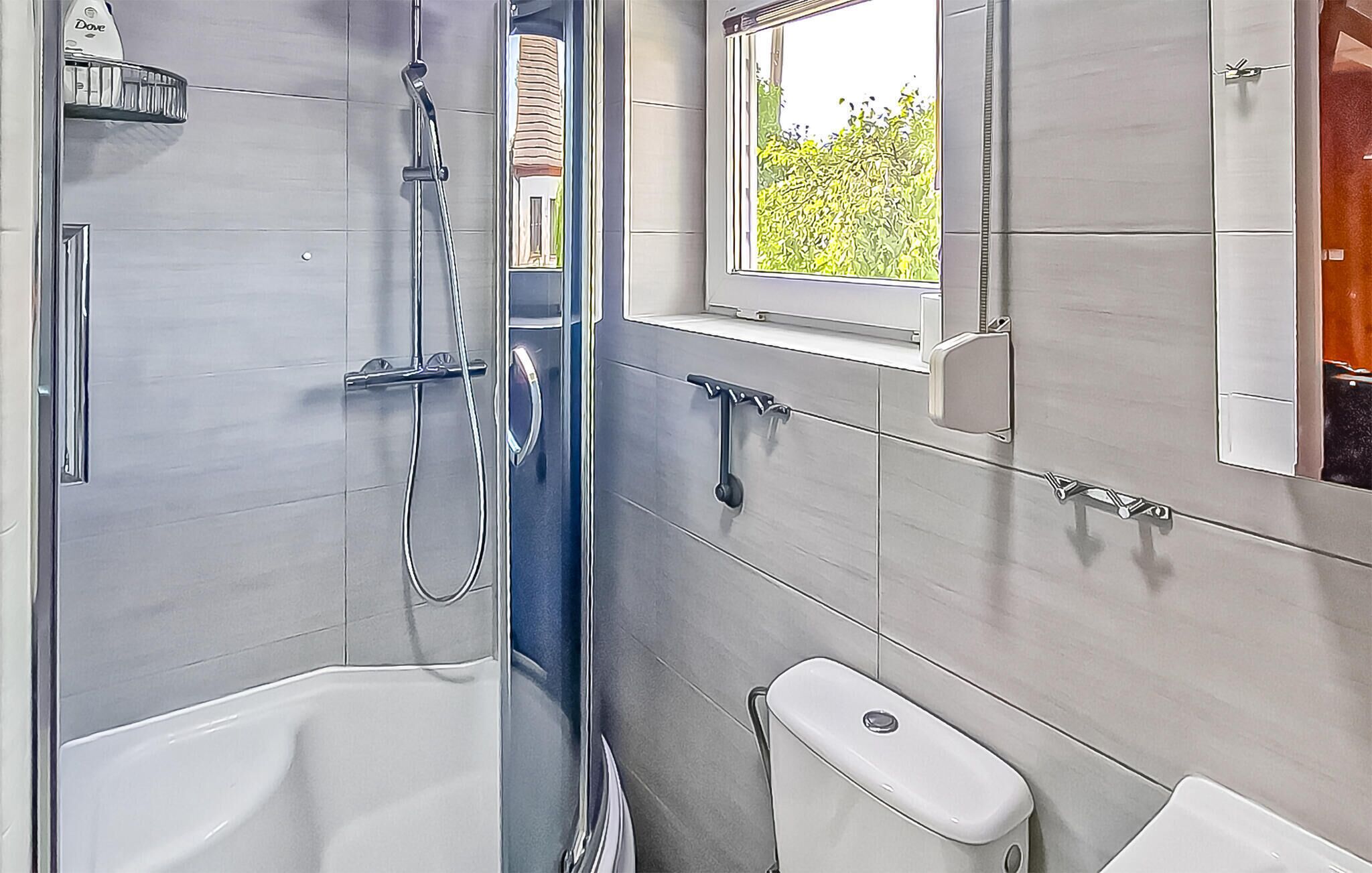 Un baño moderno con bañera, inodoro y ducha.