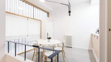 Una habitación moderna y bien iluminada con una mesa de comedor redonda, sillas y una pequeña planta en maceta.