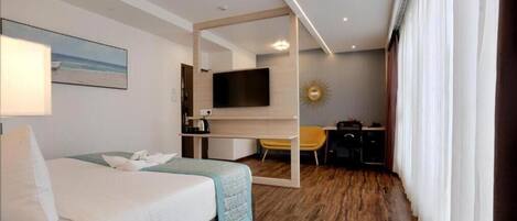 A hotel room with a bed, a desk, a TV, and a chair.