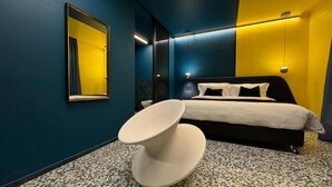 Een moderne hotelkamer met een bed, een ronde tafel en een grote spiegel.