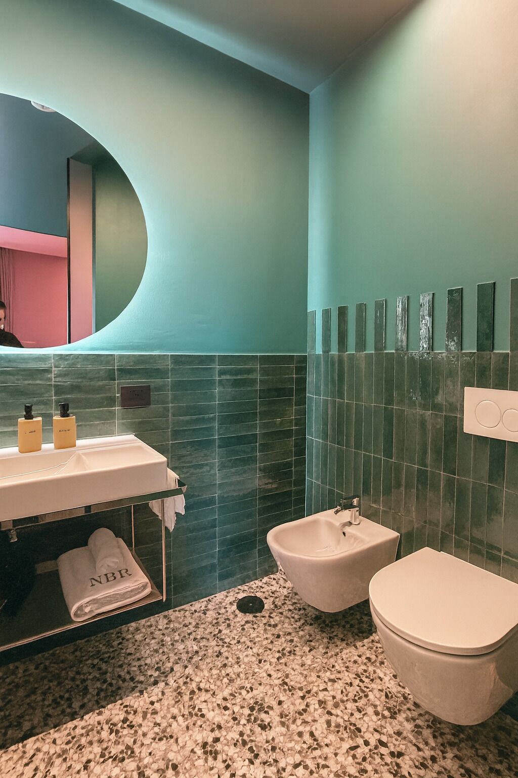 A bathroom with a sink, bidet, and toilet.
