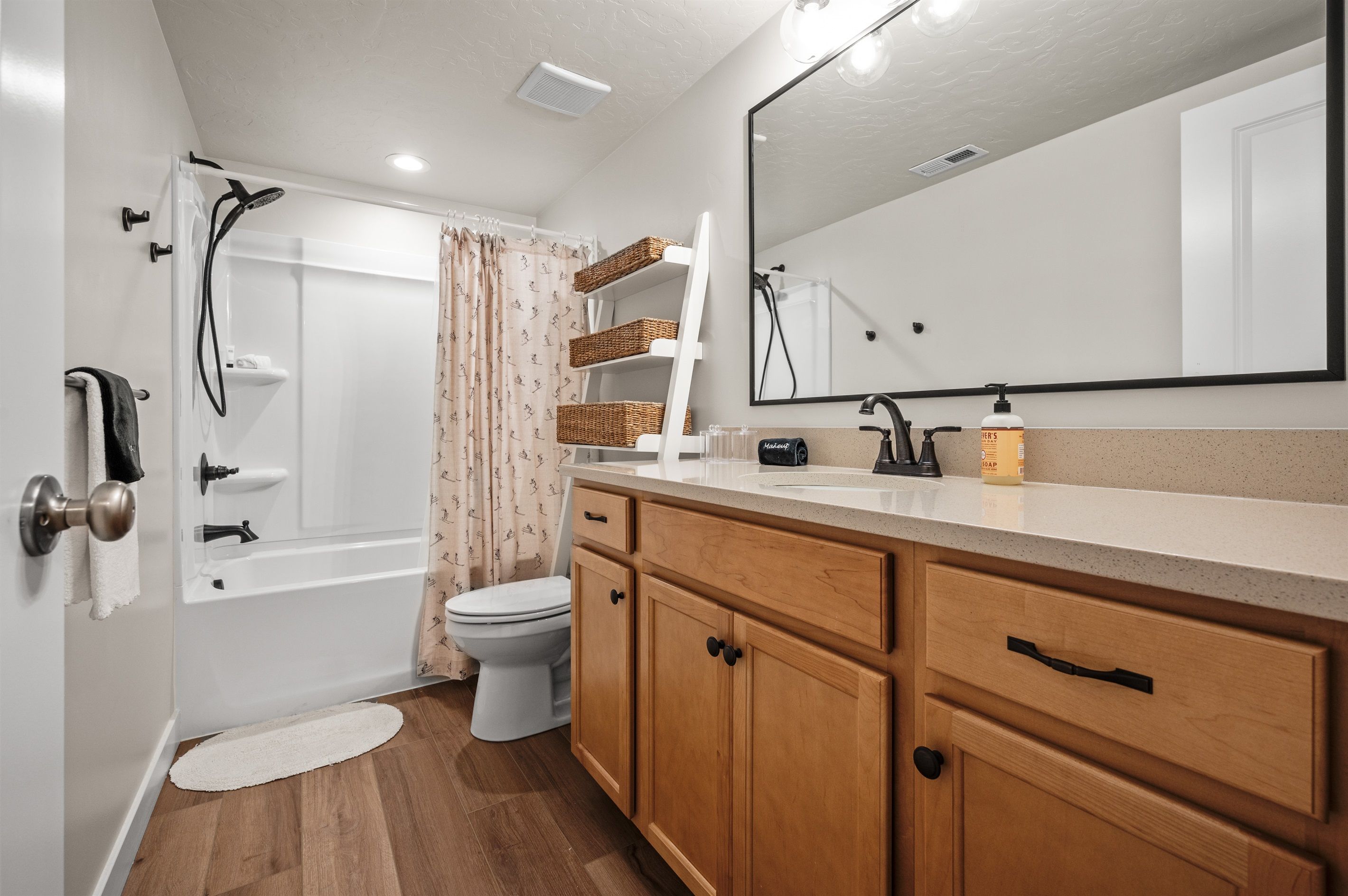 A modern bathroom with a shower, toilet, and vanity.