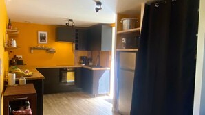 A compact kitchen with a wooden countertop, a built-in oven, and a black refrigerator. - Cosy house 5 min from Poulziourec Beach! (Groix)