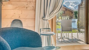 A cozy room with a large window, a wooden interior, and a view of a mountain. - Champagny en Vanoise - Premium Apartment 6 ppl, Terrace, WIFI, Parking (Champagny-en-Vanoise)