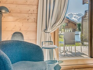 Une pièce chaleureuse avec une grande fenêtre, un décor intérieur en bois et une vue sur une montagne.