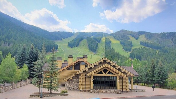 A log cabin-style building with a large entrance and a view of a mountainous landscape. - Cozy Atelier Studio with views of Baldy (Sun Valley)
