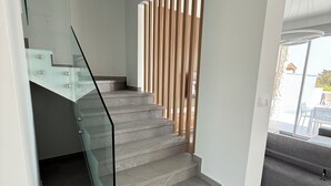 En modern trappa med glasräcken och en träpaneldesign.