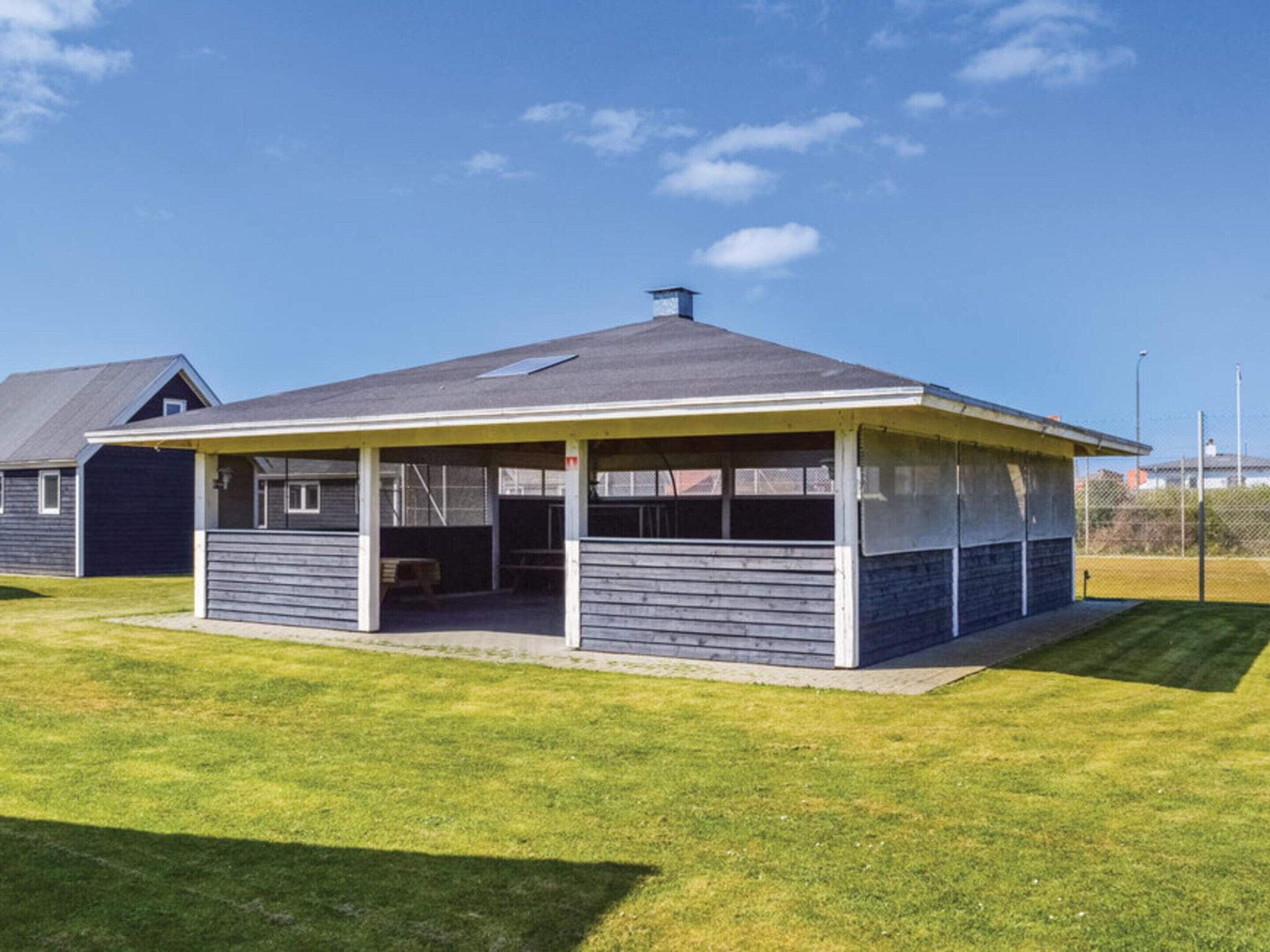 A single-story house with a covered patio area, a visible garage, and a well-maintained lawn.