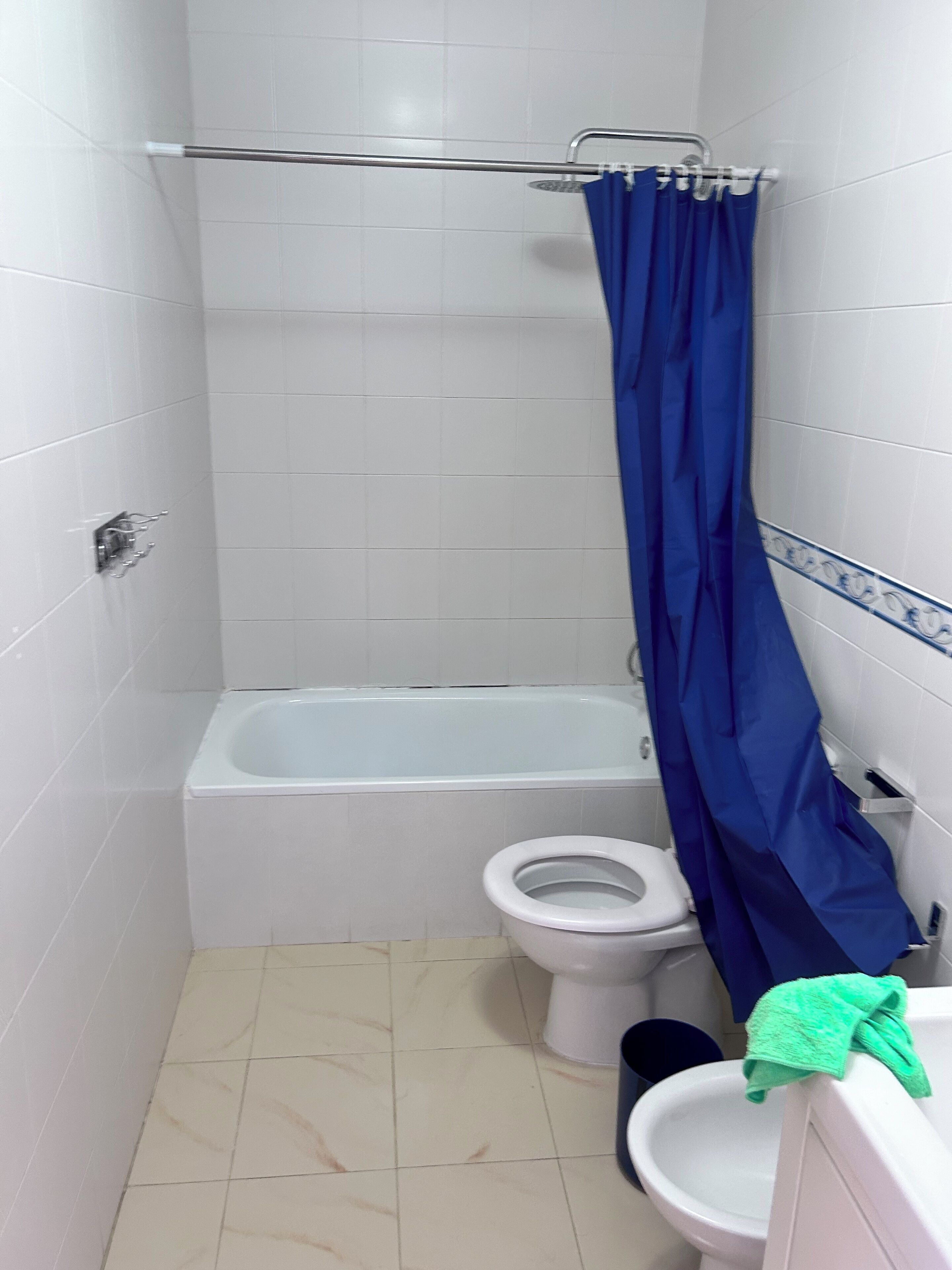 Un baño pequeño con bañera, inodoro y lavamanos.